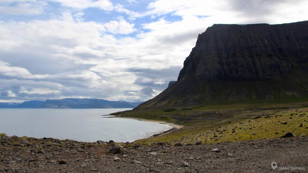 Face au fjord, les parois escarpées plongent dans l'océan.