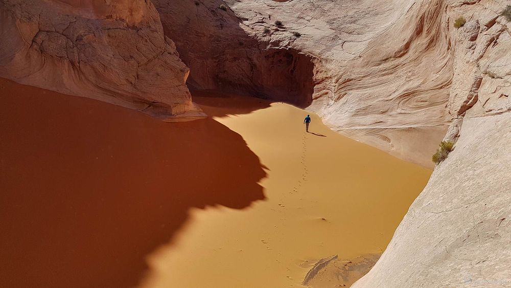 Flo laisse ses traces dans le sable orangé.