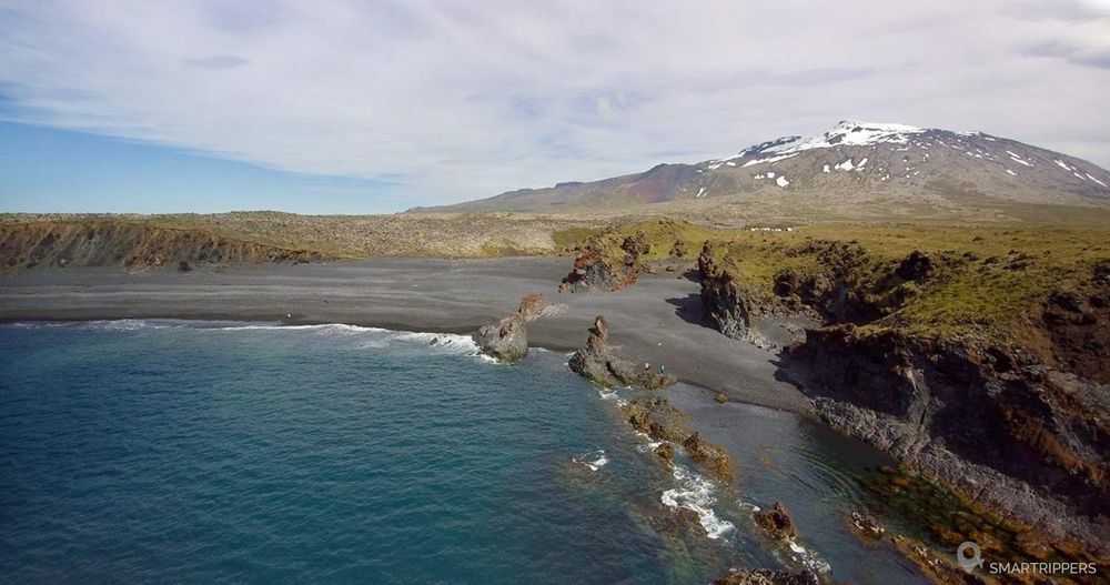 Prise de vue en drone de la plage de Djúpalónssandur, le Snæfellsjökull en toile de fond.