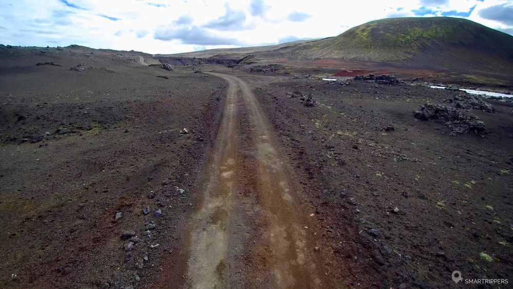 La piste s'engage dans un champ de cendres noires.