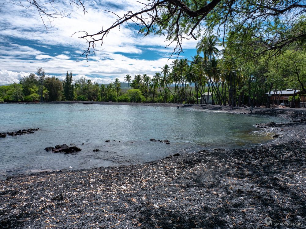 La baie bordée de cocotiers dans le fond.