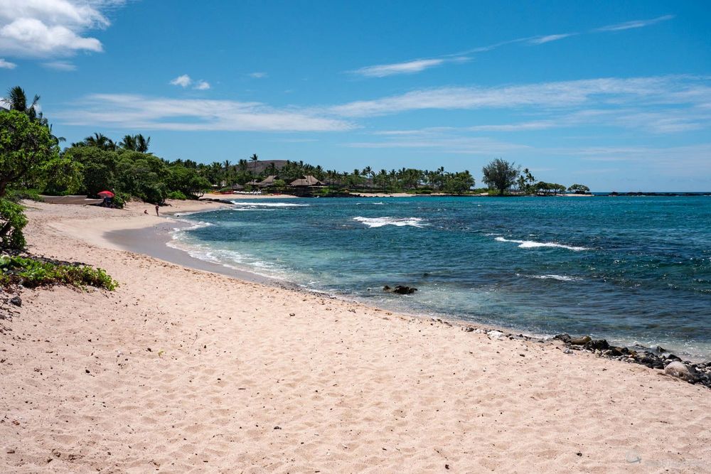 La plage s'étend sur une bonne partie de la baie.