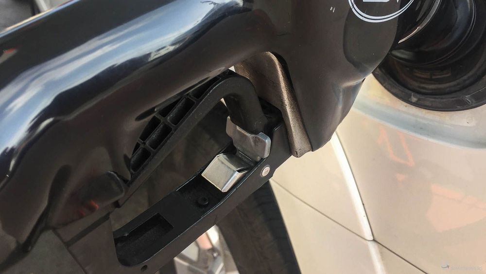 Close-up on the metal tab to be lifted to lock the gasoline gun.